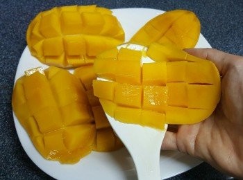 step13: 將呂宋芒洗淨，一開二，再用刀子在芒果上介十字，可以借住飯勺很容易把芒果粒弄出來