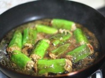 step6: 等辣椒皮表面煎至焦黃，加一碗水，慢慢的煮熟。如果之前的餡偏淡，這時你可以適當放多點醬油調味。