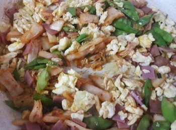 step3: 平底鍋加一匙油燒熱 , 加一匙蒜泥炒香 , 再順序加入泡菜 , 火腿片 , 蛋碎 , 荷蘭豆炒勻