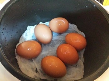 step1: 先將一張濕透的廚房紙巾放入電飯煲內，再放入雞蛋，按烹煮按鈕。當跳至保溫按鈕時(約6-8分鐘)，即可過冷河，將蛋殼敲裂。