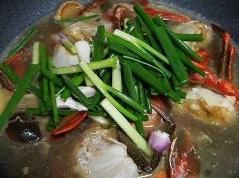 step3: 再加入蟹螯略炒，下紹興酒略炒，加入熱水直至蓋過蟹件，下鹽拌勻，放入葱和蟹蓋，加蓋大火煮15分鐘，即成。