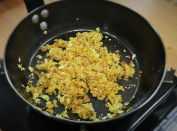 step2: 步驟2：
取炒鍋放入奶油熱鍋，加入蒜末和洋蔥末拌炒，炒至表面焦黃並冒出香味，再加入一半的蟹肉與蟹腿炒約5分鐘，接著倒入一半的高麗菜炒軟，調入1.5小匙鹽和黑胡椒粉拌勻即可取出備用，炒鍋洗淨後重新熱鍋倒入沙拉油，放入泡菜、和剩餘的蟹肉、蟹腿、高麗菜一同拌炒，收乾湯汁後調入1/2匙的鹽與糖即可取出備用。