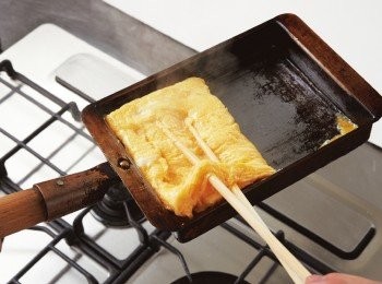 step7: 將前半部的煎蛋往後折疊，疊於後半部蛋汁的上方。