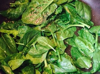 step4: 用同一隻鑊，加少許油，先放入已拍過的蒜頭炒香。加入嫩菠菜（Baby Spinach）、鹽和黑椒，炒匀至菠菜開始變軟，夾起蒜頭，菠菜留用。