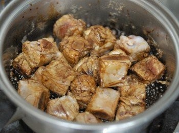 step3: 然後下老抽（甜醬油），糖及200毫升水拌勻，煮沸後，轉小火，蓋上鍋蓋煮45分鐘（要不時攪拌，令顏色均勻，如沒有水，要加水，以免燒焦）