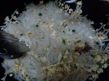 step10: 倒入雞蛋和適量瑤柱絲，倒入2茶匙史雲生調味雞汁炒至入味，倒入蔥花炒勻；
加1茶匙生抽炒勻，倒入瑤柱絲炒至混合