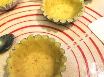 step4: [做<span class="group_1">撻皮</span>] 雪好的粉糰拿出來，用刀切開一小塊， 放在手心上，再用另一隻手壓成平面，放上撻模，輕輕用手指壓實，多出來的<span class="group_1">撻皮</span>用手指抹走