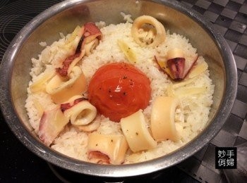 step2: 接著在放上一顆洗淨的牛番茄在正中心並且周圍放上洗淨切塊的花枝,最後撒上適量的黑胡椒,蒸好以後用飯匙把所有配料攪拌均勻即可