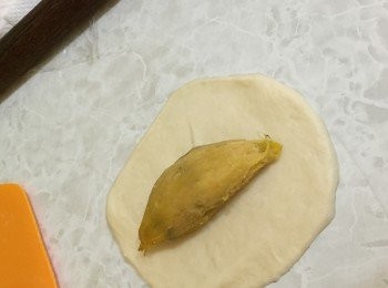 step5: 麵團用木棍壓開，放入小蕃薯，包裹後收口朝下放到烤盤上。