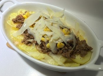 step3: 半湯匙油熱鍋, 將免治牛肉和乾葱碎炒香，熄火下半茶匙糖，3湯匙茄汁拌勻。從焗爐中拿出薯片，將碎牛鋪在薯片上。再鋪上粟米粒、黑椒碎、芝士碎。入焗爐200度焗15分鐘即可。