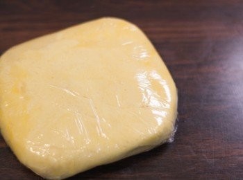 step5: <span class="group_1">撻皮</span>粉團放到保鮮膜上，輕手快速按成一團，過程中千萬不要揉搓粉團！用保鮮膜包好，大約壓成方塊狀，放入冰箱（refrigerator）約 1 小時以上至粉團變冰凍（可過夜）