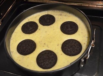 step8: 將麵糊倒入模具中，輕輕敲打模具，將內部氣泡敲出，並在麵糊上放上幾塊完整的Oreo 餅。