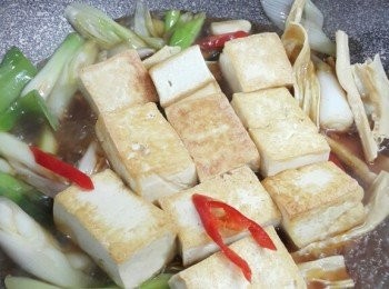 step5: 除蔥段尾部之外,,逐一炒香<span class="group_2">配料</span>,,倒入<span class="group_4">汁料</span>後,,再加入枝竹及豆腐,,用細火煮約8分鐘