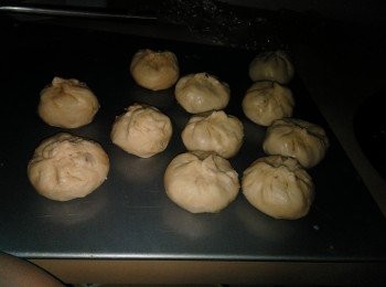 step14: 包入馅料以包包子的手法折起.排放在烤盘上，涂上一层蛋液，放入预热烤箱以180度烤15分钟。.取出包子， 晾凉一会， 大约15分钟，再涂上一层蛋液，洒上少许芝麻（随意），放入预热烤箱以180度烤烤15-20分钟至金黄色即可。 把烤好的成品放置在架子上晾凉一会， 防止包子底部受潮。