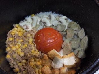 step2: 電飯煲內先放米及平常煮飯用水量，中間放蕃茄，然後於空位平均鋪上其他材料。灑上適量橄欖油、鹽及黑胡椒，按制煮飯。