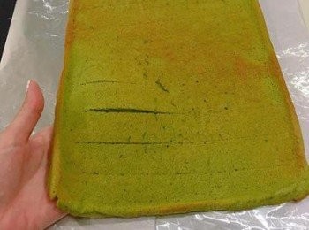 step5: 蛋糕放涼後在桌上鋪好鋁薄紙(光亮面朝上),將蛋糕倒扣在鋁薄紙上，再輕輕撕去烘焙紙。並用小刀在上面劃刀以方便捲起來時比較不會裂開（不要劃穿喔）