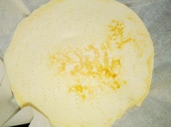 step6: 先暫時熄火,將麵皮拿起,在鍋子鋪上烤盤紙,再將麵皮重新放回鍋子裡,這次將烤成焦色的麵皮朝上,白色還未烤的朝下