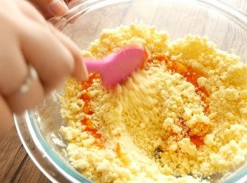 step5: 完成步驟4後，混合物會呈麵包糠般的酥鬆狀態。加入步驟2己混合的蛋黃和雲呢拿香油，以膠刮或大木匙拌勻成團，如太乾至成不了團，可逐少加入淡奶拌勻。注意麵團不用太濕，水份（包括蛋黃、雲呢拿香油和淡奶）只要足夠混合成團即可，如蛋黃較大，甚至不用下淡奶。