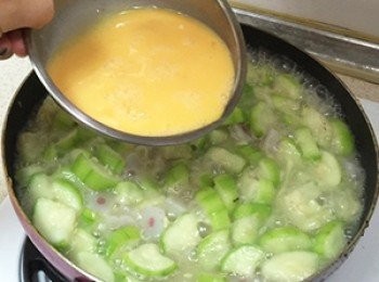 step6: 以中小火悶煮1~2分鐘，使絲瓜軟化出水後，淋上蛋液，平均淋在絲瓜上，蓋上蓋子熄火。