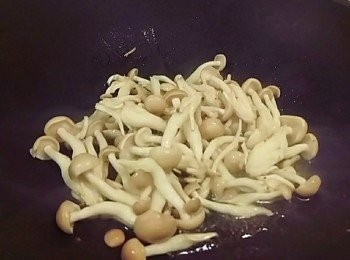 step2: 熱油鍋後放入鴻禧菇加入米酒略炒 炒軟即可