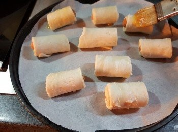 step3: 芝心腸卷放在牛油紙上，將一隻雞蛋打成漿，腸卷掃上二次蛋漿（用牛油紙是不會痴底）