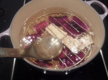 step4: 將茄子下鍋汆燙至熟(水滾時茄子再下鍋,煮約3-5分鐘,依茄子數量多寡而定)。保留茄子美麗紫色表皮的秘訣之一:水裡建議加一匙白醋,及利用不銹鋼濾網架或大漏勺壓住茄子,只要茄子完全浸泡在熱水中不接觸到空氣,即可保留茄子的紫色外皮。