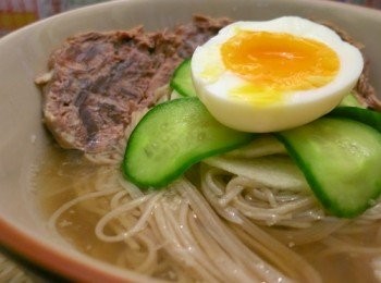 step6: 韓國蕎麥麵先浸暖水大約5分鐘，用手一條條撕開
煮沸水，下麵條煮30秒瀝乾，用凍水過冷河再完全瀝乾，放入碗內
把湯拿出來，如果太冰可用刀拍散成碎冰，先加至剛到麵的頂部
牛展解開保鮮紙，切片後放入碗內
把梨片、白蘿蔔片、青瓜片排好在麵上面
雞蛋切半放在最上面即可