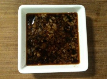 step4: 【調製蒜泥醬】：等待水煮滾的時間，調製蒜泥醬。取出小碟子，將「淬釀日式和風醬油露－北海道昆布」放入，再將蒜頭用搗蒜器壓成蒜泥放入。