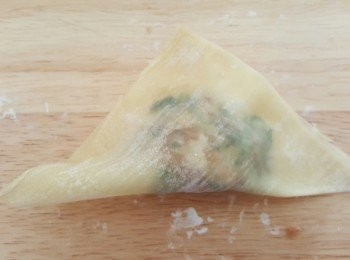 step7: 第二款將雲吞皮菱形放，餡料放雲吞皮上3份1，雲吞皮上半部沾水（不用4邊，會太多水太濕），向上對摺，由右到左隨意摺，完全對摺前留下一角先將皮內空氣壓出，這樣會比較靚，最後壓一下皮邊定形即成