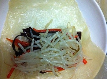 step7: 腐皮以乾淨的濕布抹抹，將材料放上腐皮中間位置再捲成卷狀。