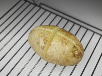 step2: 接著把微波後的馬鈴薯十字內均勻的抹上奶油~~ 放進預熱180度的烤箱烤到外皮裂開為止!!! 約15-20分鐘即可^^ (請依據馬鈴薯大小.烤箱溫度不同調整一下烘焙時間!!)