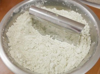 step2: 加入奶油以瓜刀切成碎丁狀呈現蓬鬆狀態後，倒入雞蛋液、牛奶攪拌成麵糰，將葡萄乾揉入麵糰內。