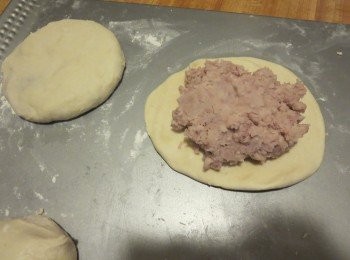 step4: 包入3分之1的饀料,接口處捏緊。桌上撒些粉,將包好的餅壓扁,輕輕擀圓。