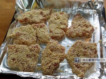 step3: 把多餘的醃料抹去，裹上芝麻，放入已預熱的蒸焗爐，選"健康炸"功能25分鐘。(或放入已燒熱的油以中火炸至豬排呈金黃色。