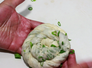 step11: 一邊搓同時開始往內捲, 形成蝸牛狀。收尾壓在餅的下方。在煎煮時, 以收口的一面先下鍋。