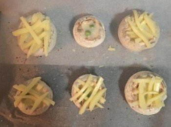 step3: 烤盤上鋪烘焙紙，將蘑菇放在上面，用少許的鹽和胡椒粉調味後倒入蛋液(確實每個蘑菇都放入青豆)，接著排上起司條，入烤箱烤15分鐘到起司呈金黃即可,出爐後擺盤並撒上切碎的巴西里葉，便可享用囉～