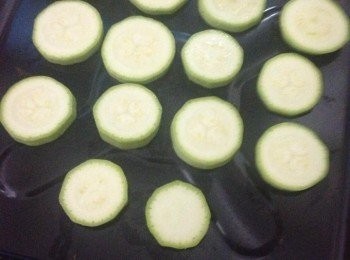 step5: 在焗盤上放在烘焙紙，然後將切好的翠肉瓜鋪在上面。(翠肉瓜焗後會軟身,芝士也可能痴著焗盤,用烘焙紙會較易拿出上來)