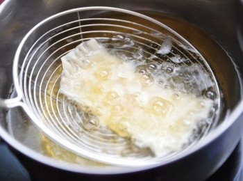 step3: 先用濾網輕輕的放入油鍋炸不翻動，讓杏仁片固定住不會掉落，炸至微微的金煌及可撈起瀝油