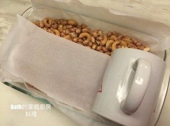 step5: 再鋪上烘培紙，用圓形容器如馬克杯壓緊糖果
