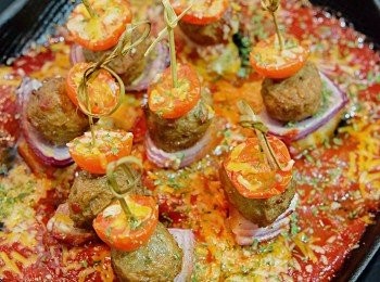 step6: 將蕃茄醬汁倒入焗盤，放上肉丸串，撒上少許車打芝士，放入焗爐200度焗5-6分鐘至芝士溶化，取出撒上乾蕃茜碎便成。