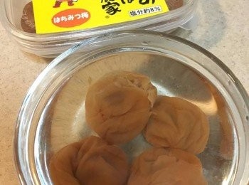 step1: 將日本梅子放入碗中，用湯匙輕壓一下，跟住加入熱水浸泡約10分鐘