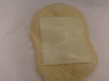 step1: 除掃麵包面蛋黃備用,所有材料放入麵包機搓一小時三十分左右,攞出排氣後將粉團分成三份後,將芝士放入每一份的麵團裏卷好。