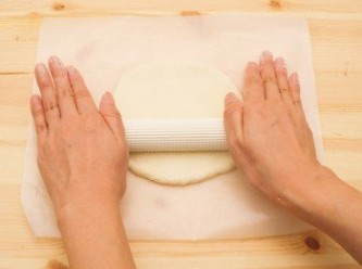 step3: 將麵團依希望完成的片數均分後揉圓。 把麵團放在烤盤紙上，再使用擀麵棍擀開。
