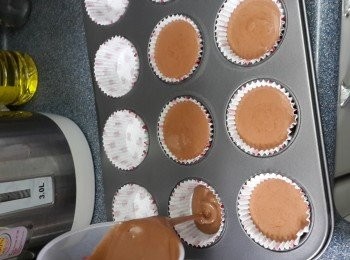 step9: 將12個cupcake紙托放於cupcake盆中，再將朱古力麵糊由高处倒入cupcake紙托中, 再輕輕震幾下，可震除氣泡