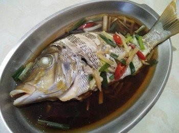 step3: 經過10分鐘後，把蒜頭放入鍋中，快接近15分鐘後，用筷子插入魚身最厚的地方，筷子若能輕鬆穿過，表示熟透了，如果還沒就多蒸2分鐘後，再試一次。