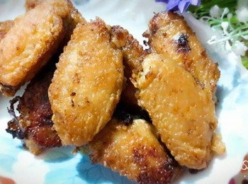 step3: 把醃漬一晚的雞翅拿出 , 麵粉倒到乾淨的容器中拌勻 , 把雞翅都沾上炸麵粉 , 平底鍋中加入6大匙油 , 燒熱後用半煎炸的方式 , 把雞翅加入炸至二面金黃即可