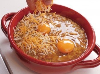 step13: 將12 盛入耐熱盤中。在中間打上蛋，鋪上乳酪絲，放上迷迭香。注意不要將蛋黃弄破，蛋黃上也要確實鋪上乳酪絲。