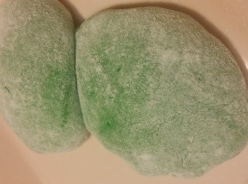 step4: 粉團蒸好立即拌好拌勻，粉團表面更光滑。
粉團待暖和，便可戴上手套。
將粉團分成8分，用手將粉團大约搓圆形，用手掌压平，小心慢慢拉闊至適合芒果肉的闊度，放上芒果肉，將每邊向中心對摺收口，用手再慢慢修正形狀。