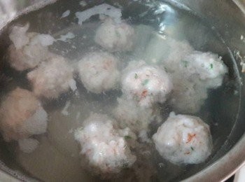 step6: 燒一鍋清水 , 不用沸騰 , 維持沸點狀態就可以 , 把蝦漿用手從虎口中擠出 , 用湯匙接著蝦丸並滑到熱水中 , 煮至蝦丸浮起即可