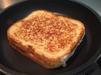 step2: 有塗牛油的那一片朝下放入平底鍋中（鍋子不放油），稍為壓一下，鍋蓋蓋上用最小火慢慢煎，約兩分鐘檢查一下，若已成金黃色則翻面，同樣再慢煎約兩分鐘